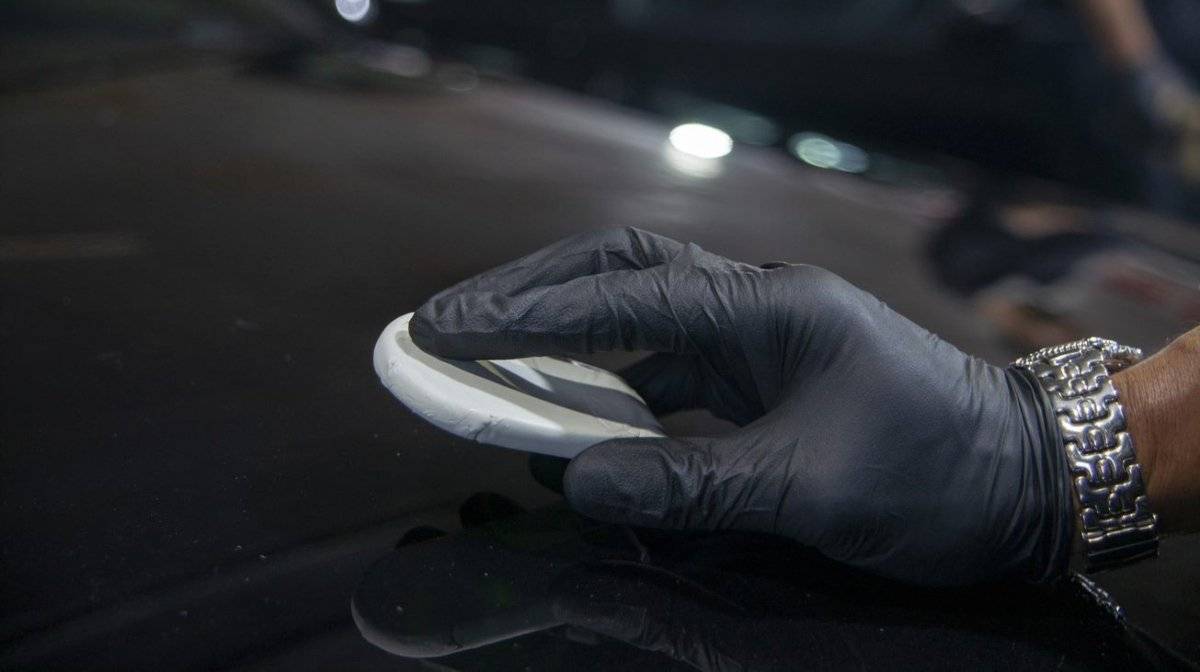 Applying clay bar to the bonnet of a car