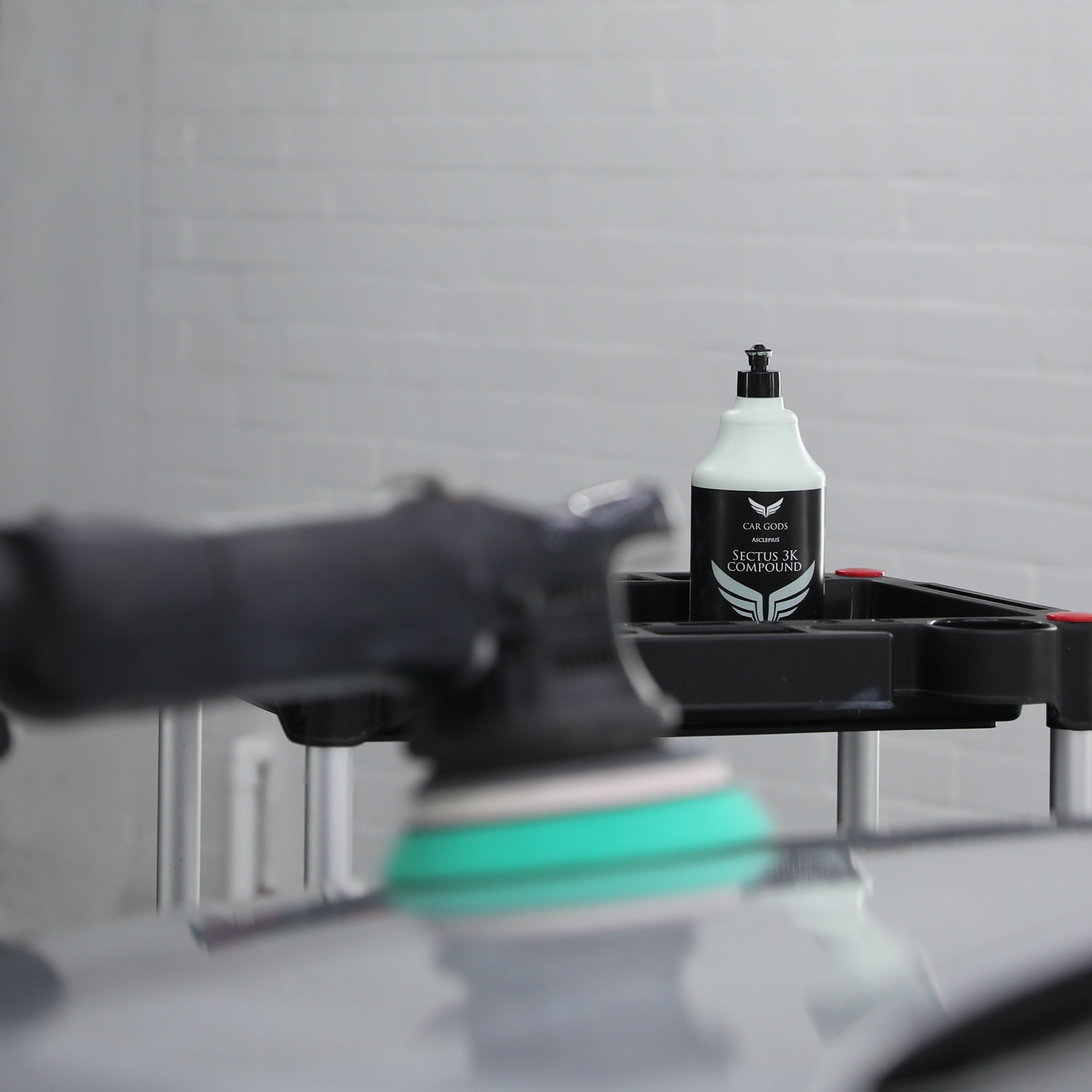 heavy cutting compound being applied to car paintwork with a machine polisher