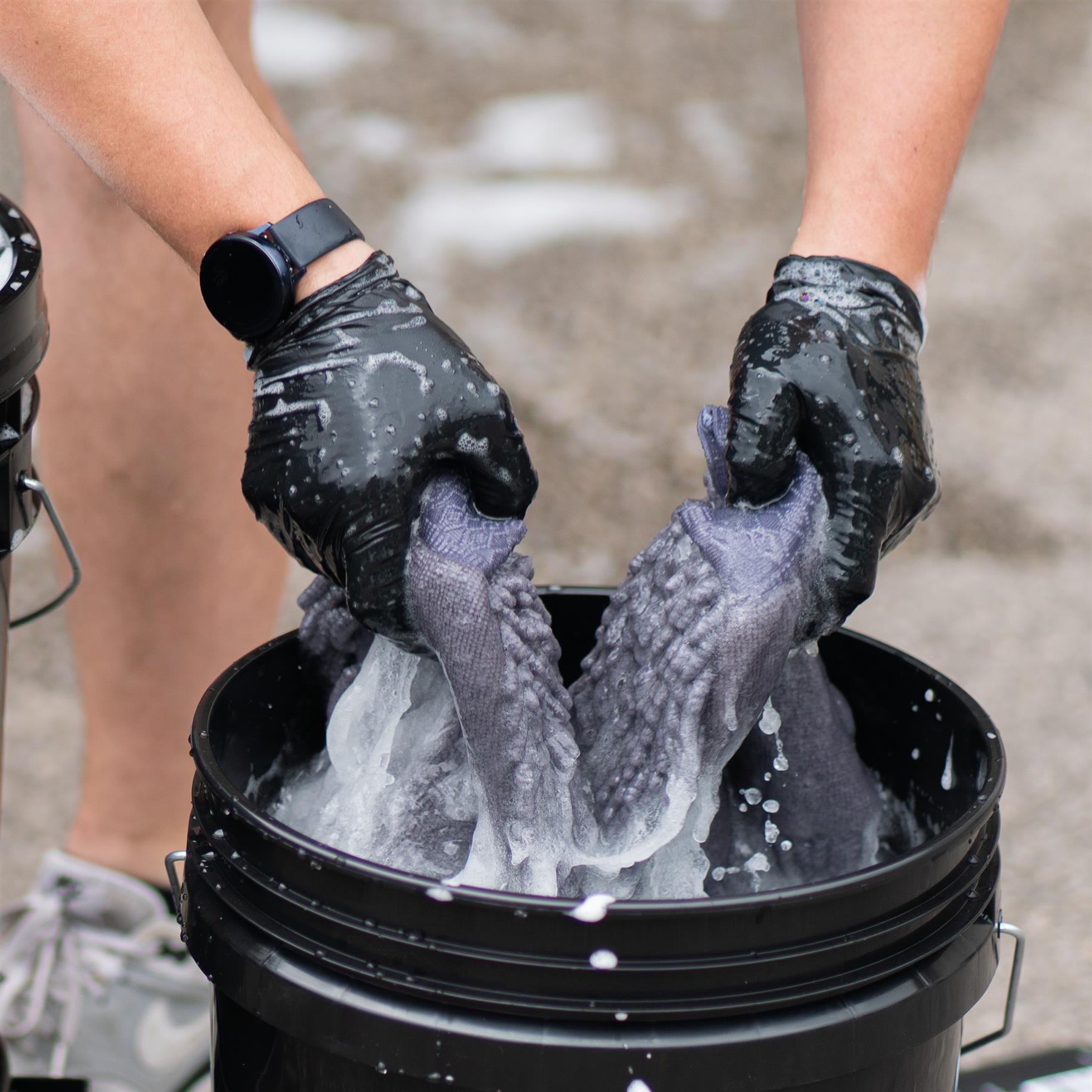 Rinsing a wash mitt in a detailing bucket