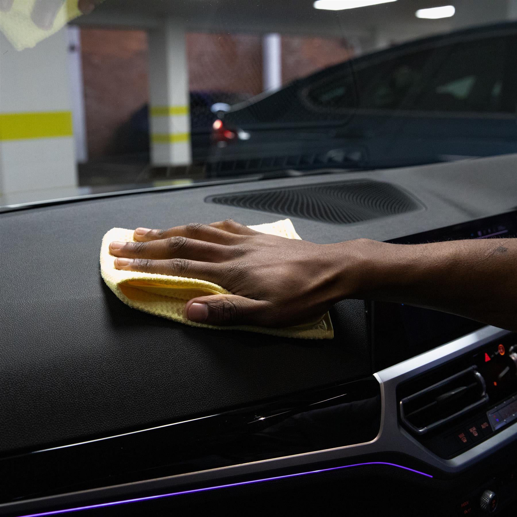 Microfibre cloth used to wipe dust from a car dashboard