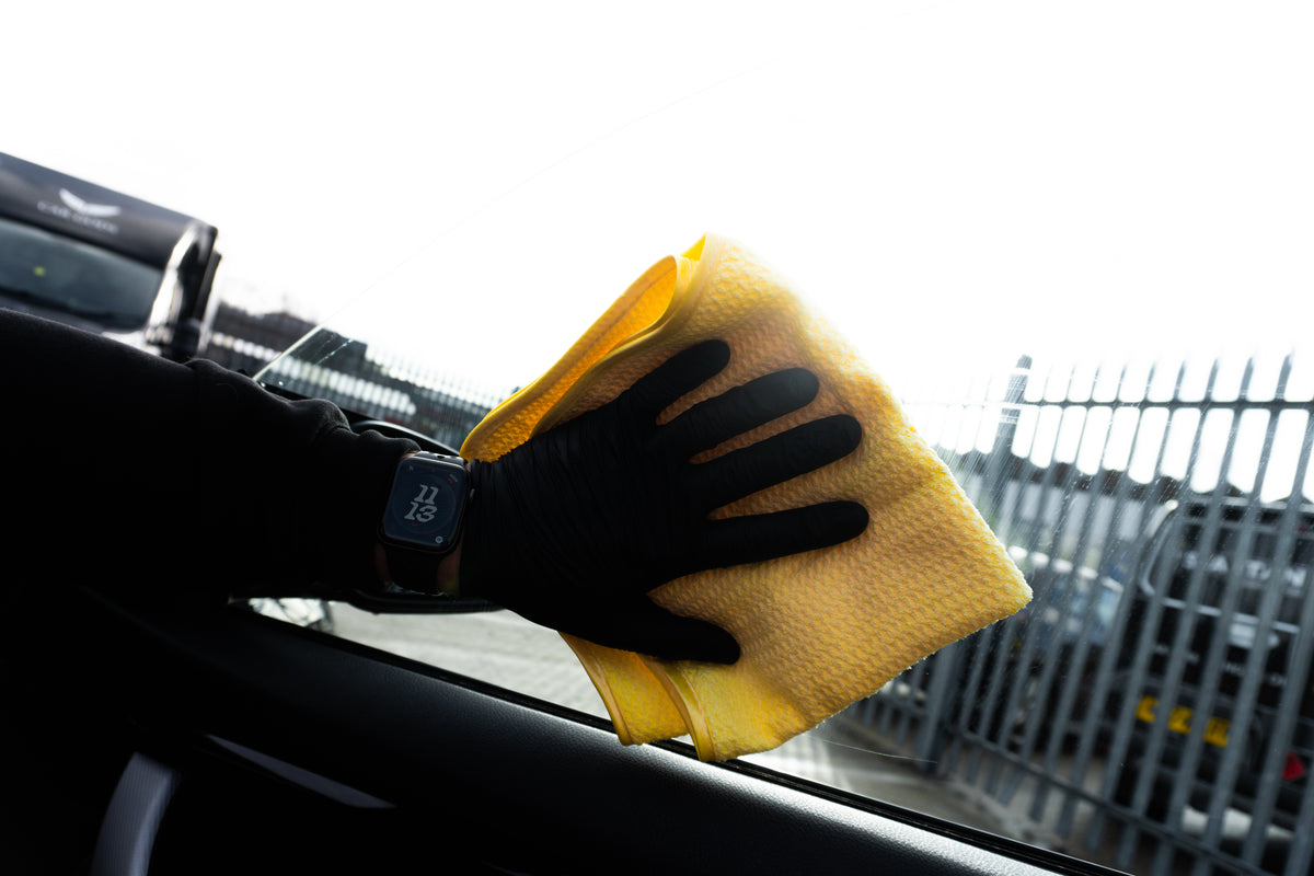glass cleaner being sprayed onto a car windshield