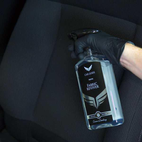 fabric reviver being sprayed on to a car seat