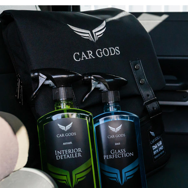 interior detailer and glass cleaner resting on the car gods backpack