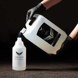 Pouring fabric reviver into a professional detailing bottle